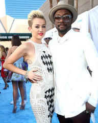 Miley Cyrus cosies up to Will.i.am for backstage pic